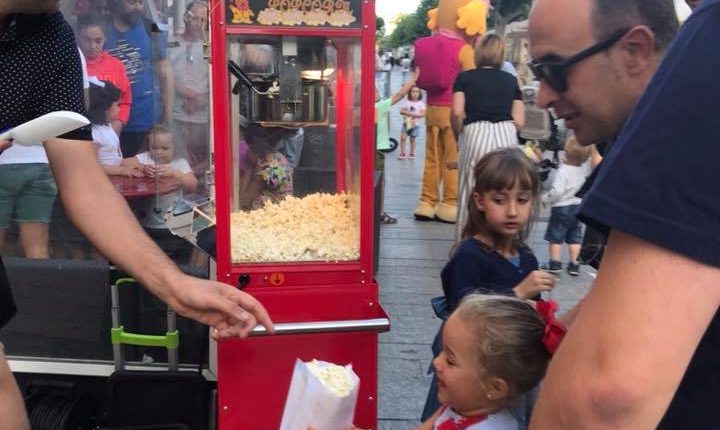 Palomitero dando palomitas a niños
